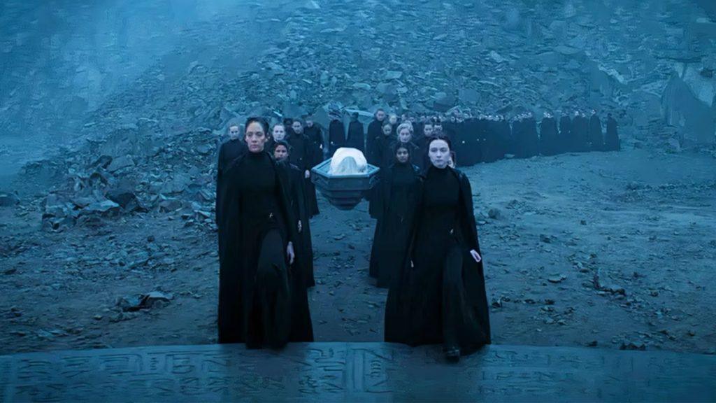 Captura de la serie en la que la hermandad de las Bene Gesserit lleva a entierro un sepulcro flotante, enfrente una de las protagonistas Anya Harkonnen